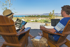 Resort Amenities Couple outside reading and working on laptop